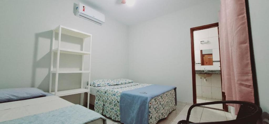 a small room with two beds and a mirror at bairro Oliveira - casa 3 quartos com ar in Campo Grande