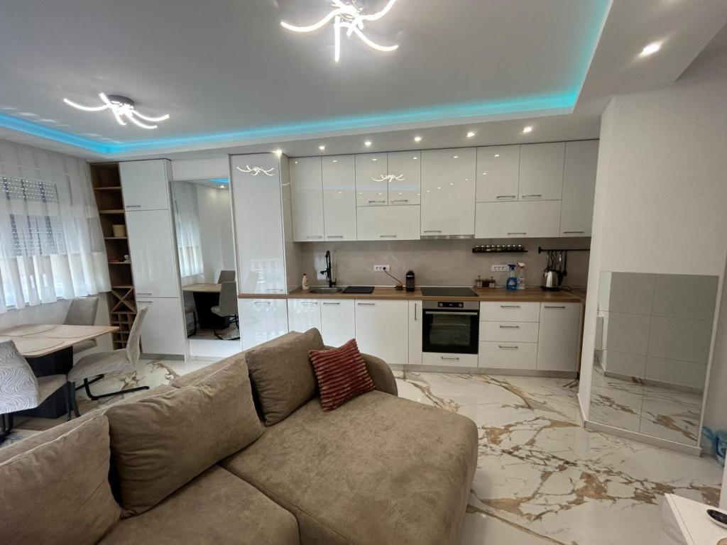 a living room with a couch and a kitchen at Stan na dan Arte in Loznica