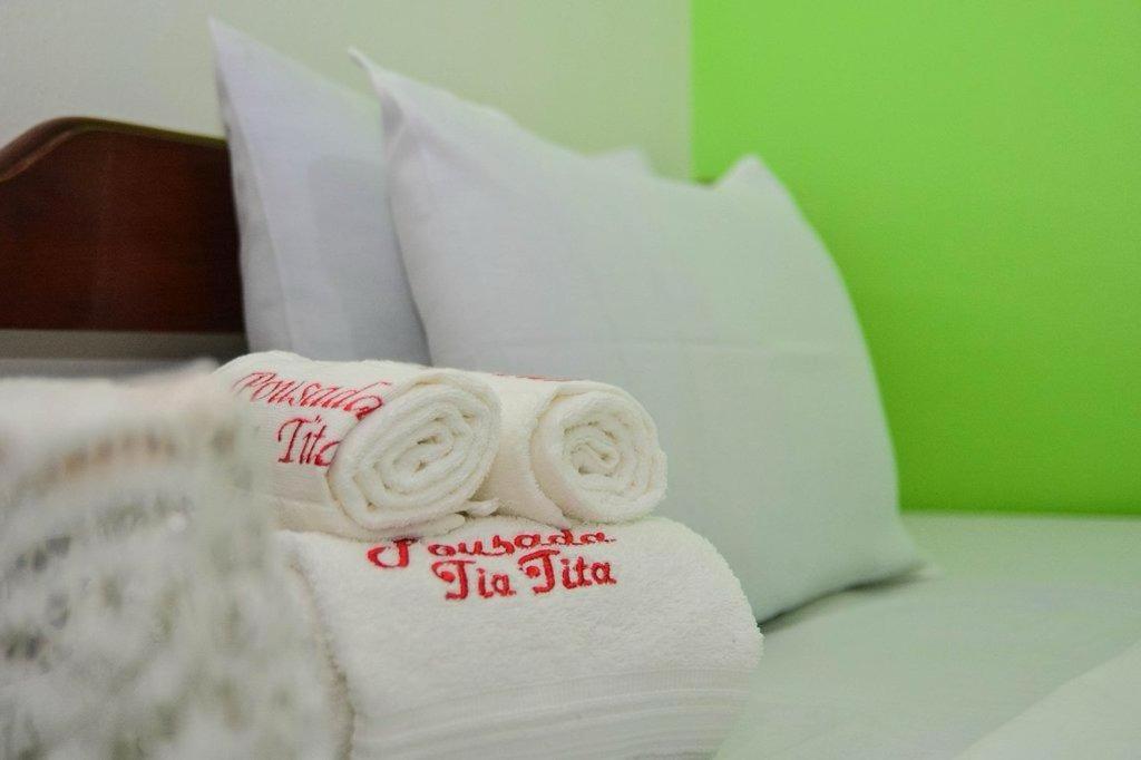 a pile of towels sitting on top of a bed at Pousada Tia Tita in Cayru