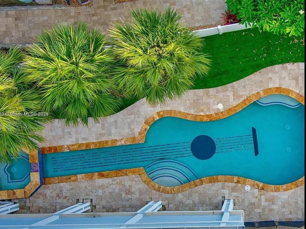 an overhead view of a swimming pool with palm trees at Oceanfront Mansion With Boat & Jet Ski in Key Largo