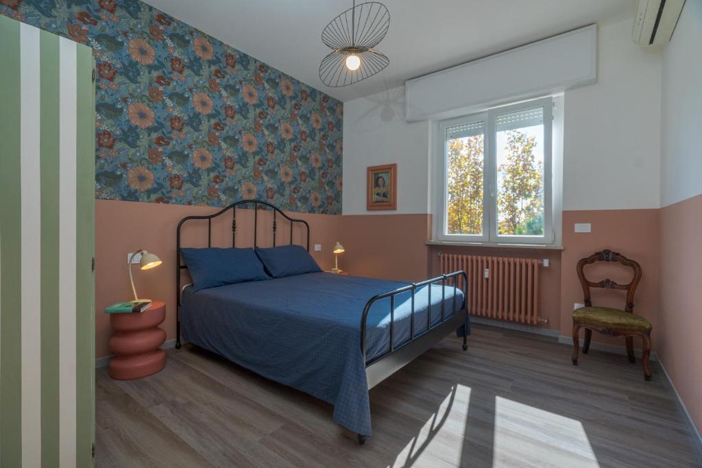 a bedroom with a blue bed and a window at Essenza Suite Appartments in Rimini