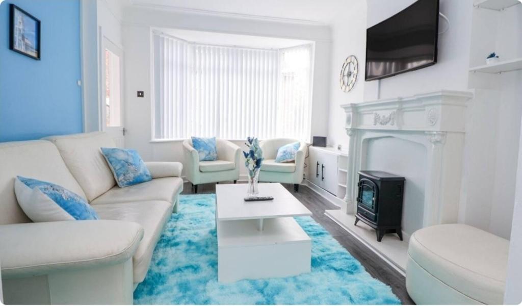 a living room with a couch and a fireplace at Anfield Stadium House - Free Parking in Liverpool