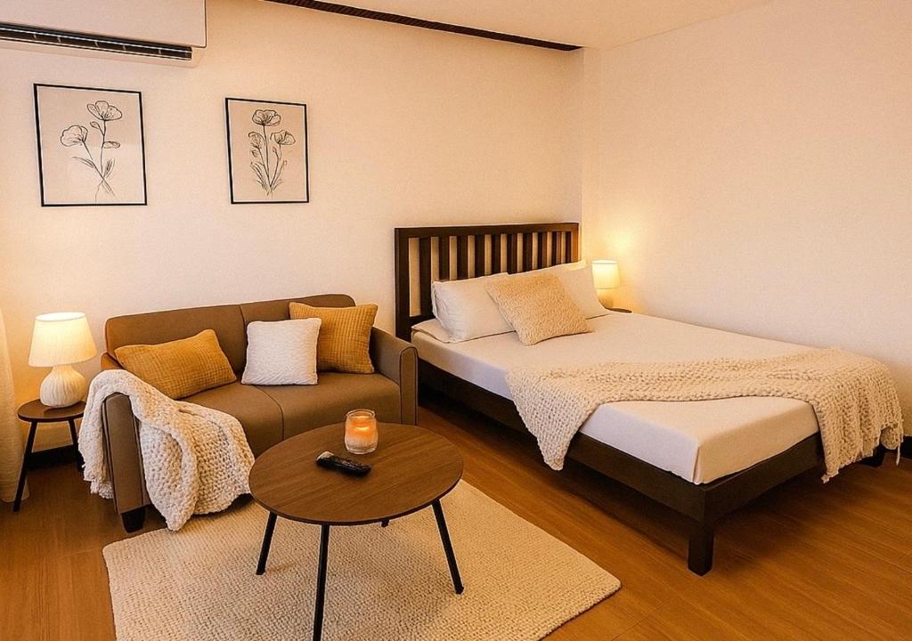 a bedroom with a bed and a couch and a table at Balai de Biday 4 Pax Suite with Free Breakfast in Mameltac