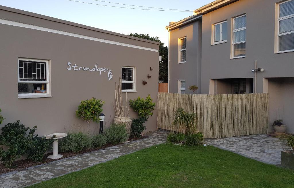 a backyard of a house with a fence at Strandloper Apartments in Hermanus
