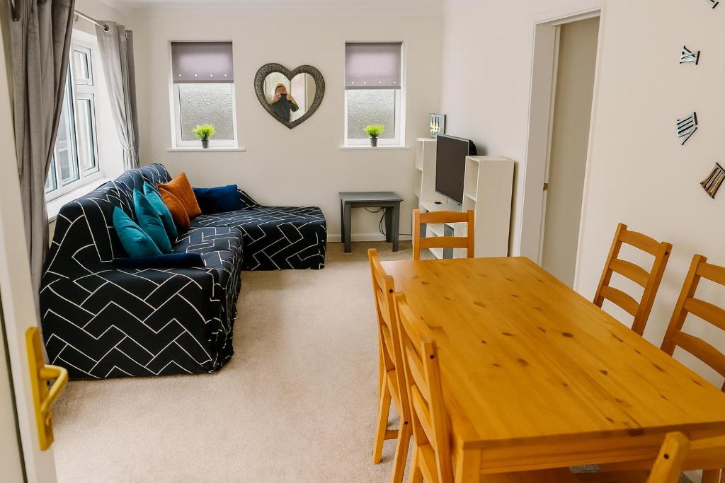 FlookburghにあるWillow Chalet near Cartmel & Lake Windermereのテーブルとソファのあるリビングルーム