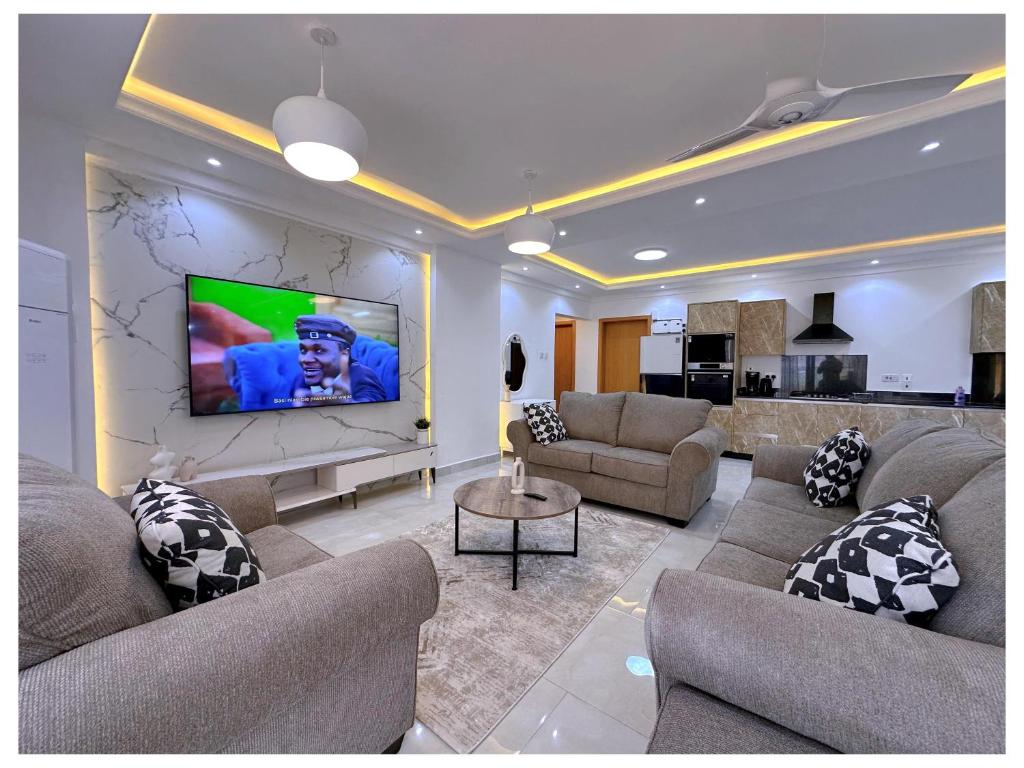 a living room with couches and a flat screen tv at Sandy shores apartments in Kikambala