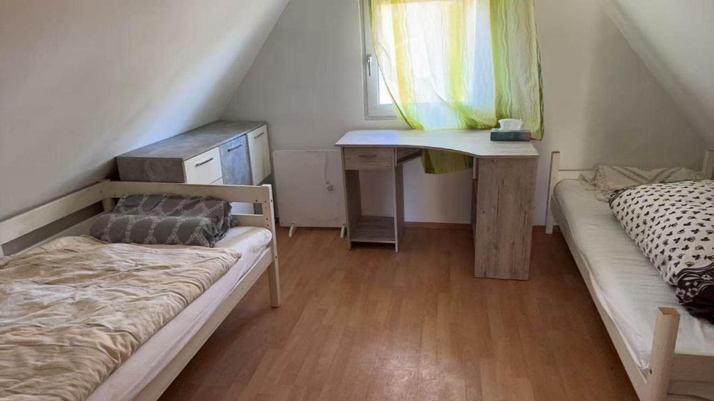 een kamer met twee bedden, een bureau en een raam bij Alex3 in Hannover