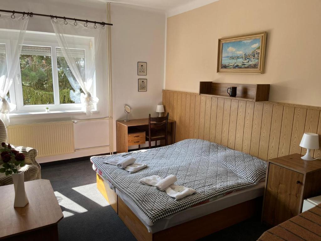 a bedroom with a bed with white towels on it at Penzion Bezděkov in Rakovník