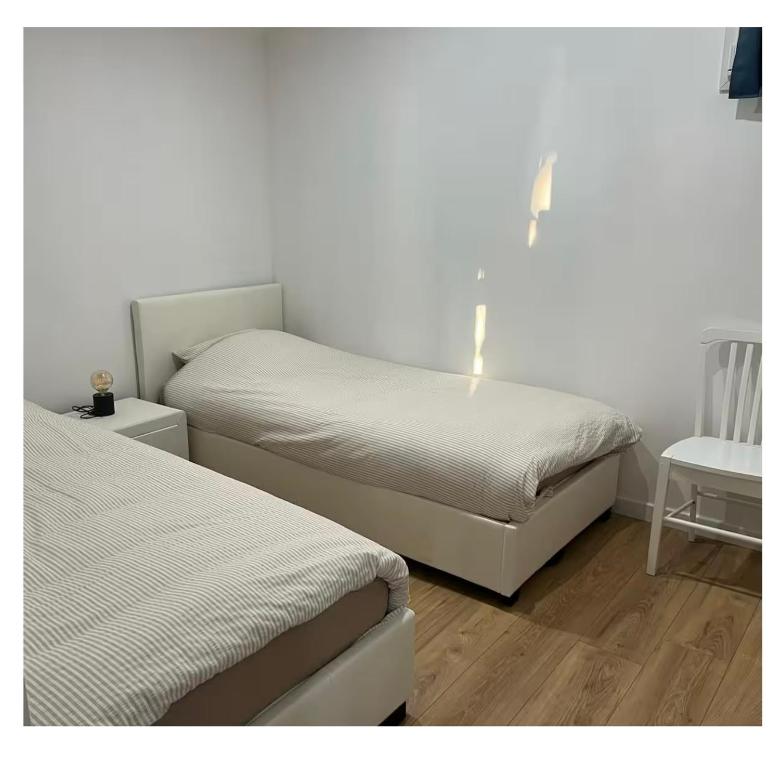 a bedroom with two beds and a table with a night stand at Appartement calme in Sigogne