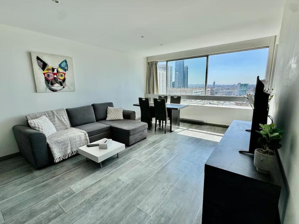 a living room with a couch and a table at Apartment Paris La Défense Eiffel Tower Skyline in Puteaux