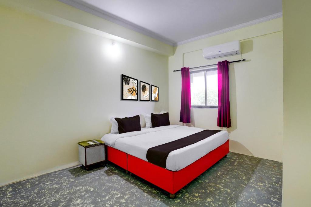 a bedroom with a large bed with a red frame at HOTEL O REEYH INN in Khāpri