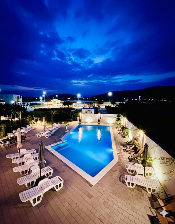 a swimming pool with lounge chairs and a resort at Quattro Apartment in Međugorje