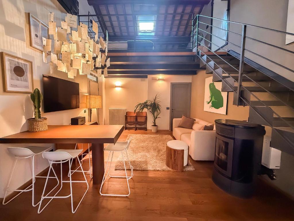 a living room with a table and chairs and a staircase at Cognaia Loft in Arezzo