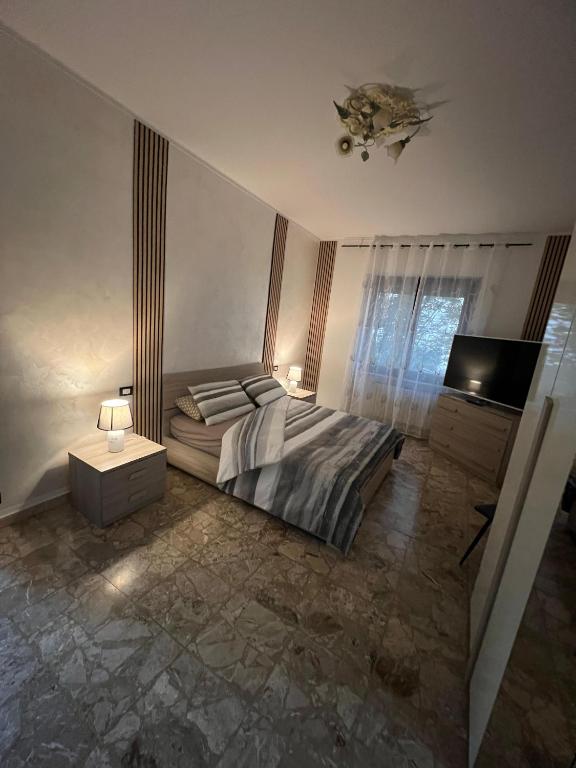 a bedroom with a bed and a flat screen tv at Relax suite in Alessandria