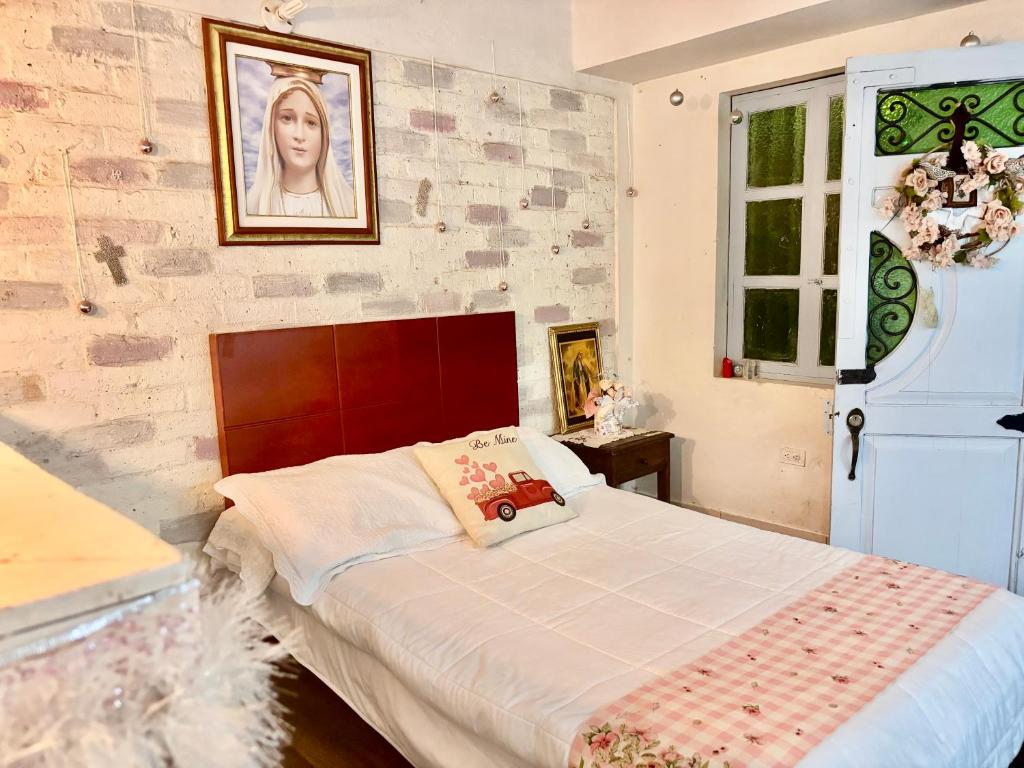 a bedroom with a bed and a brick wall at Apto-Hotel Villa de Leyva Flor de María con Terraza in Villa de Leyva
