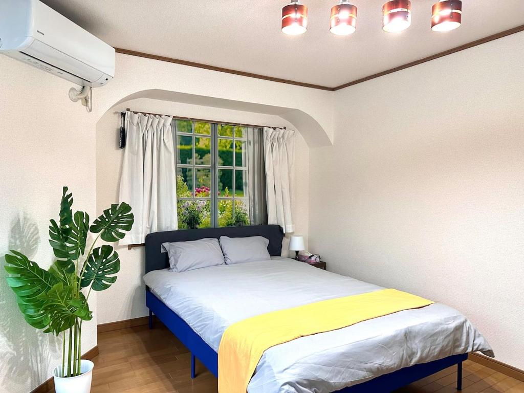 桜の宿 في أوساكا: غرفة نوم بها سرير ونافذة