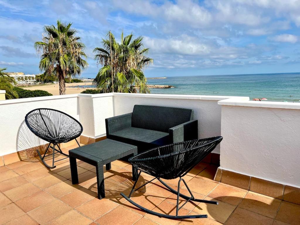 eine Terrasse mit einem Tisch und Stühlen auf einem Balkon mit Meerblick in der Unterkunft House in front of the beach in Cambrils