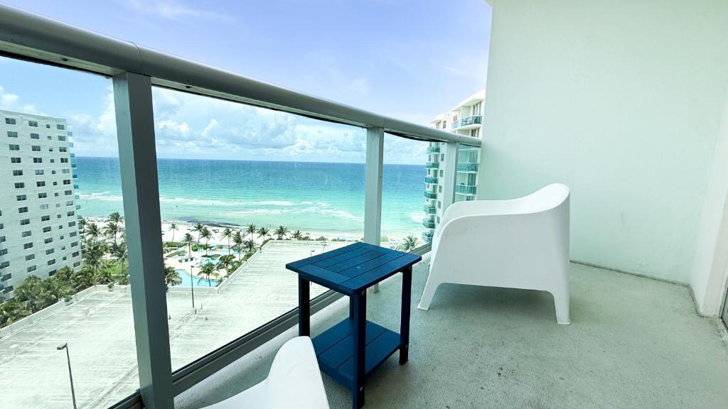 a blue table and a white chair on a balcony with the ocean at THE TIDES 2bedrooms apt 14th floor WE ARE ON THE BEACH! in Hollywood