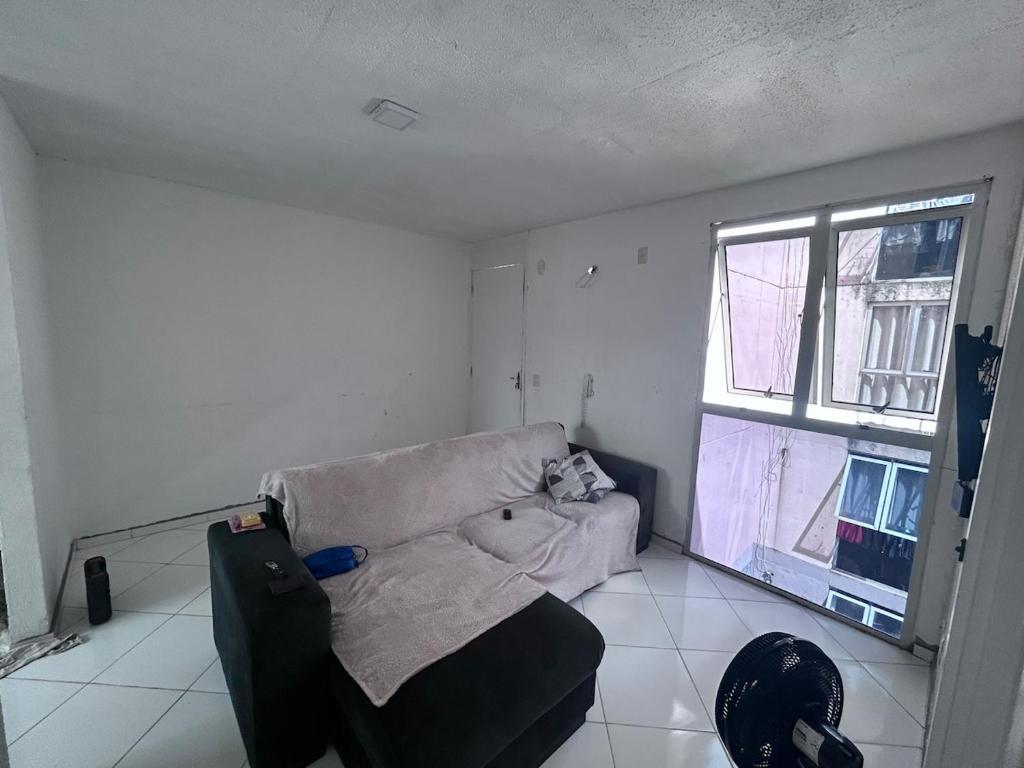 un salon avec un canapé et une fenêtre dans l'établissement Viver Melhor Apartment, à Marituba