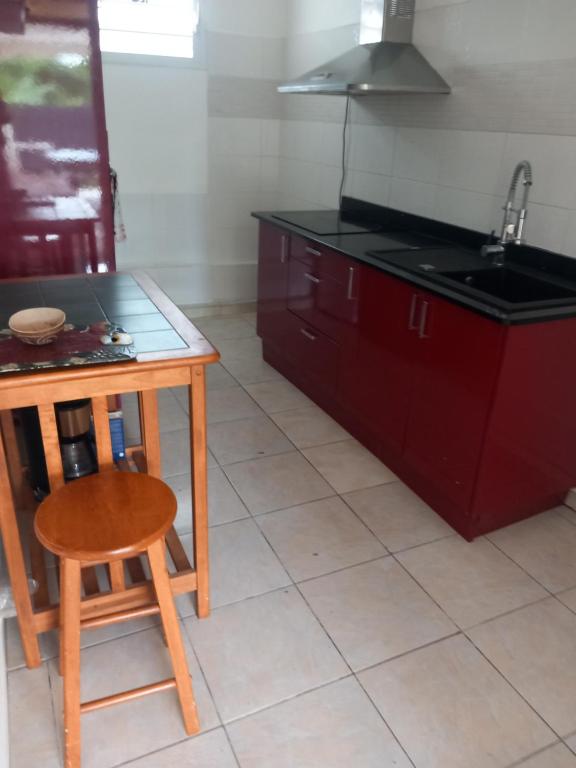 a kitchen with a table and a wooden chair at lorispring in Îlet à Christophe