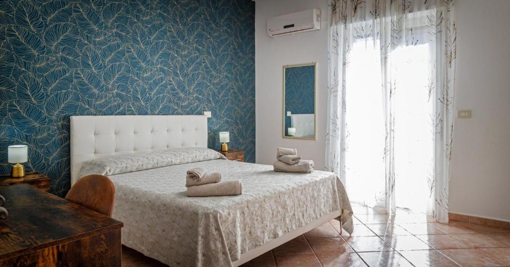 Un dormitorio con una cama con dos toallas encima. en Gli Agrumi di nonna Peppina - Appartamento Arance, en Mondragone