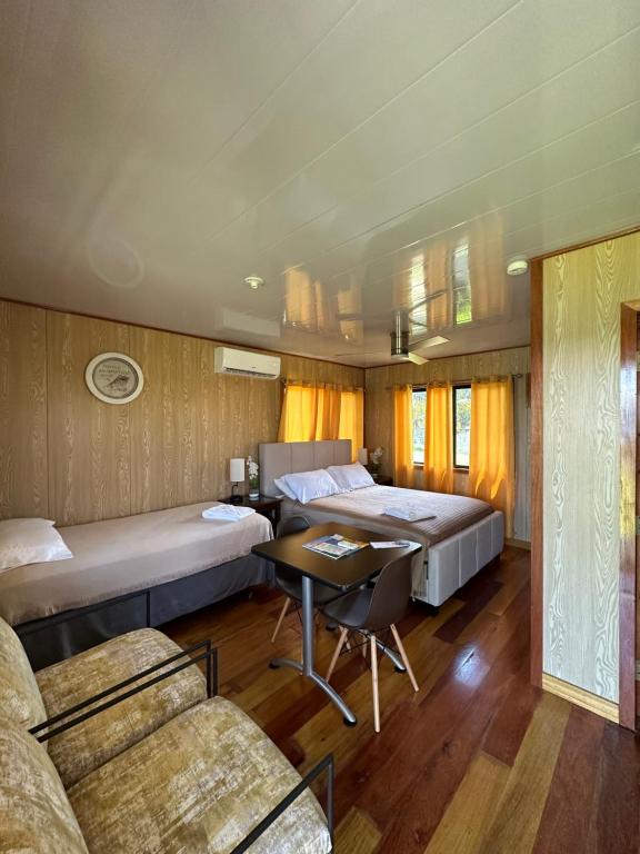 ダンリガにあるSunshine Cabanas At Ocean Viewのベッド2台とテーブルとソファのある寝室