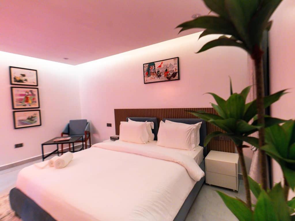 a bedroom with a bed and a potted plant at Aurum on Missouri in Abuja