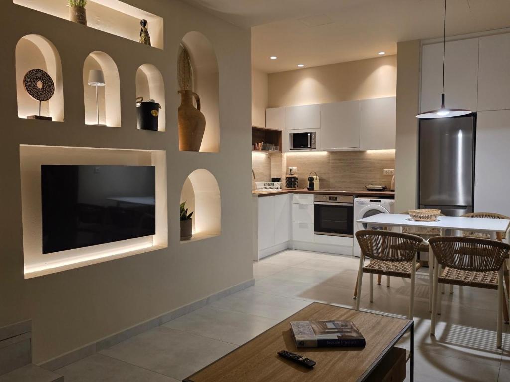 a kitchen with a table and a tv on a wall at Rastoni Suites Xylokastro 1 in Melission