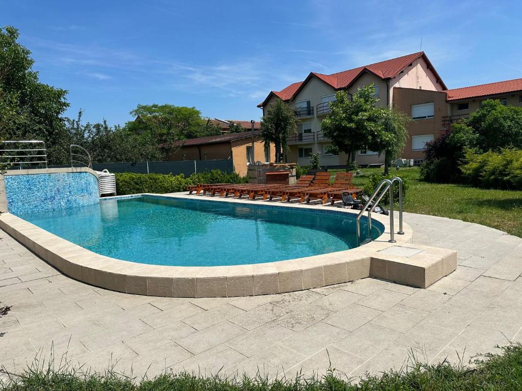 a swimming pool in a yard with chairs around it at Asgard Residence Apartaments in Timişoara