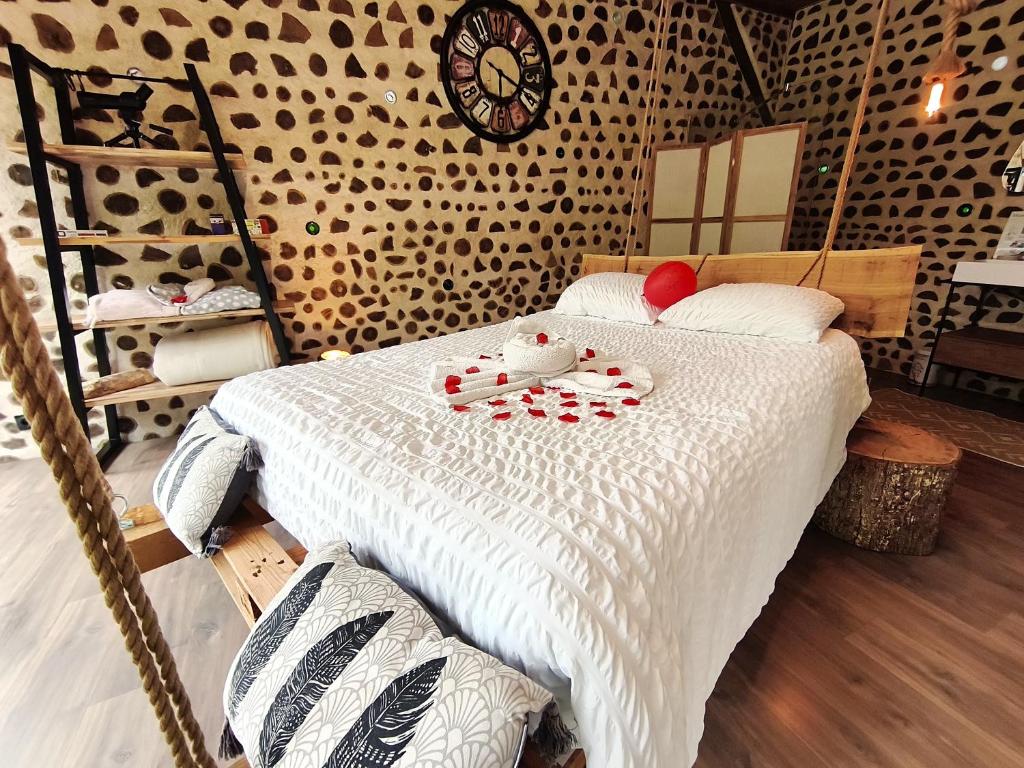 a bedroom with a bed with a clock on the wall at Au Calme Absolu chez Elodie & Aurélien in Lindry