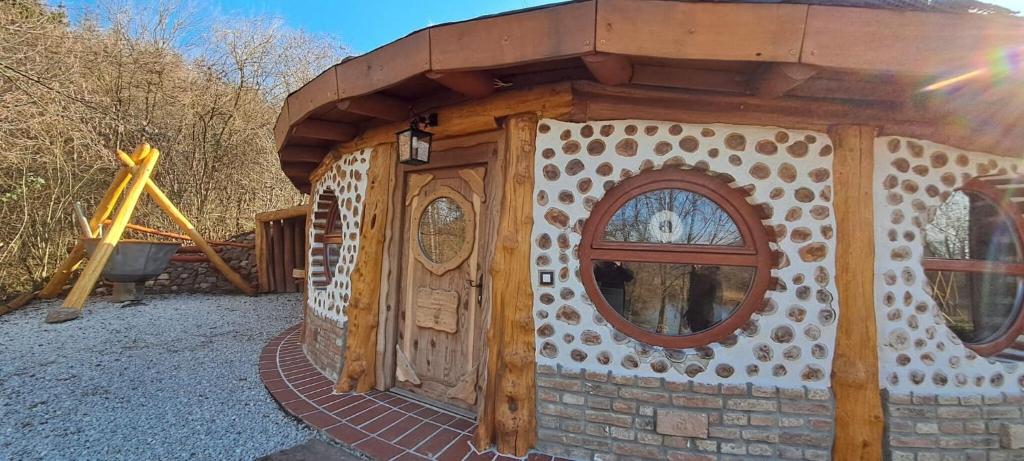 BárdudvarnokにあるŐze Hobbitházの遊び場にある3つの窓がある木造の建物