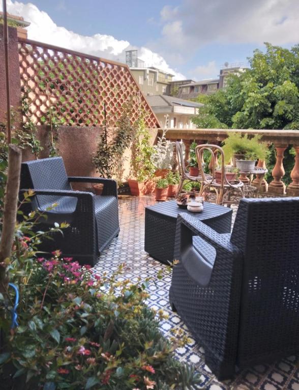 a patio with chairs and a table and flowers at Majestic Salus Spa in Fiuggi