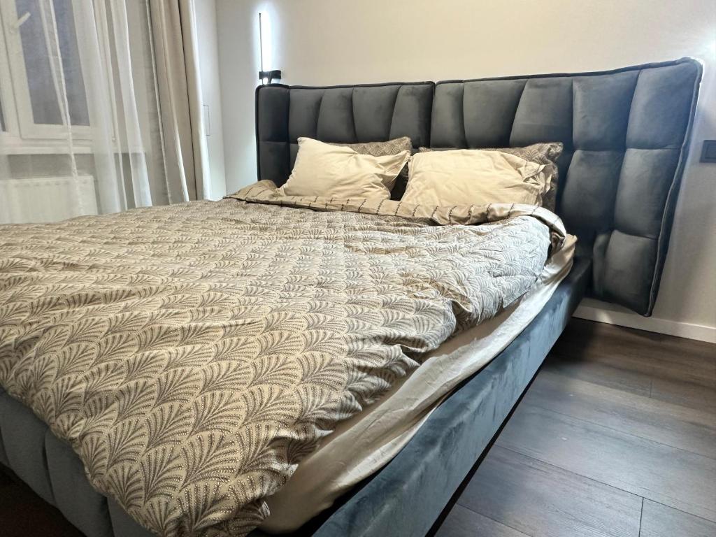 a large bed with a blue headboard in a bedroom at Lauvas Rezidences - Self check-in in Rīga