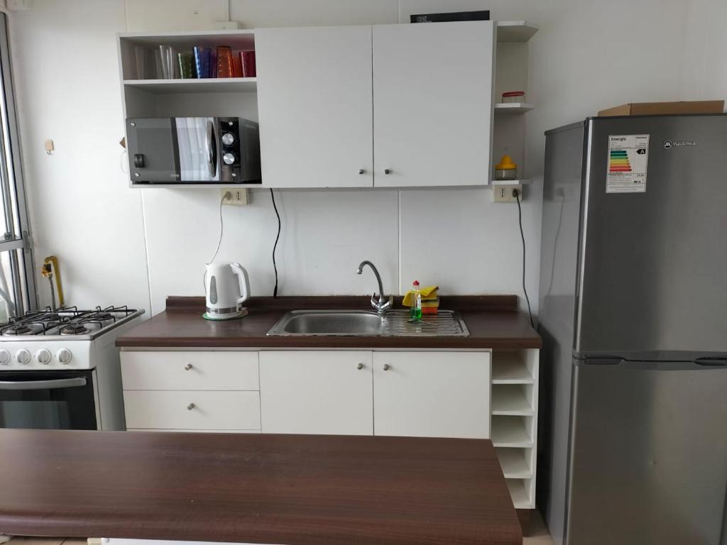 a small kitchen with a sink and a refrigerator at Noruega in La Serena