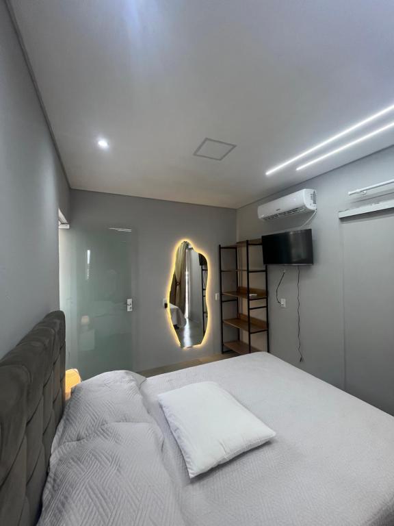 una camera da letto con un letto e uno specchio sul muro di Recanto do Sol a Governador Celso Ramos