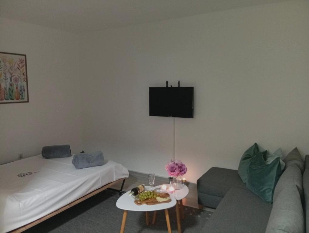 a living room with a couch and a tv on the wall at Apartman Mali kutak in Gradačac
