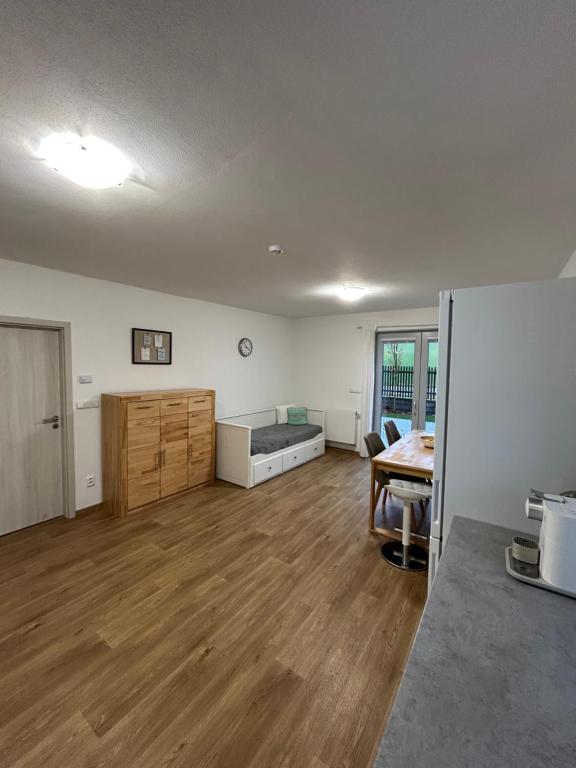 un salon vide avec un lit et une table dans l'établissement Prázdninový dům, à Kout na Šumavě