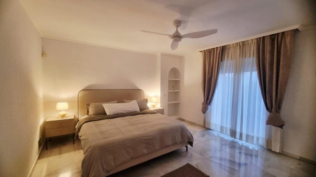 a bedroom with a bed and a ceiling fan at villa bahía banus in Marbella