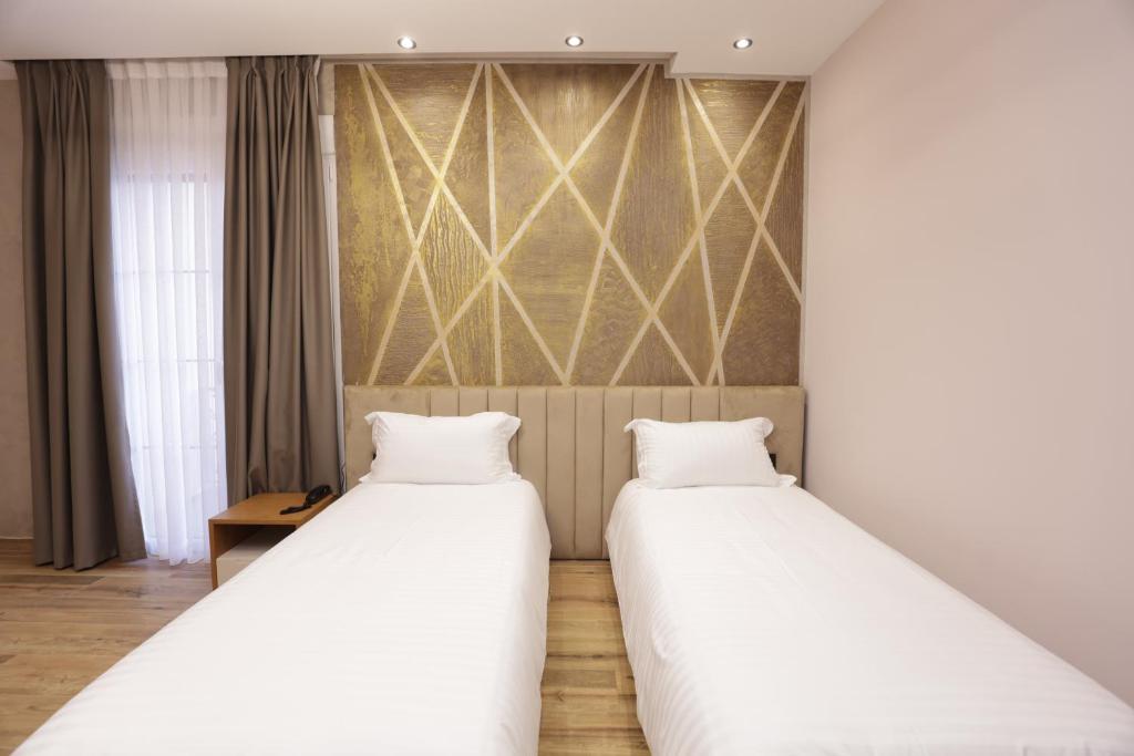 two beds sitting next to each other in a room at Comfort Rezidence In Hotel in Tirana