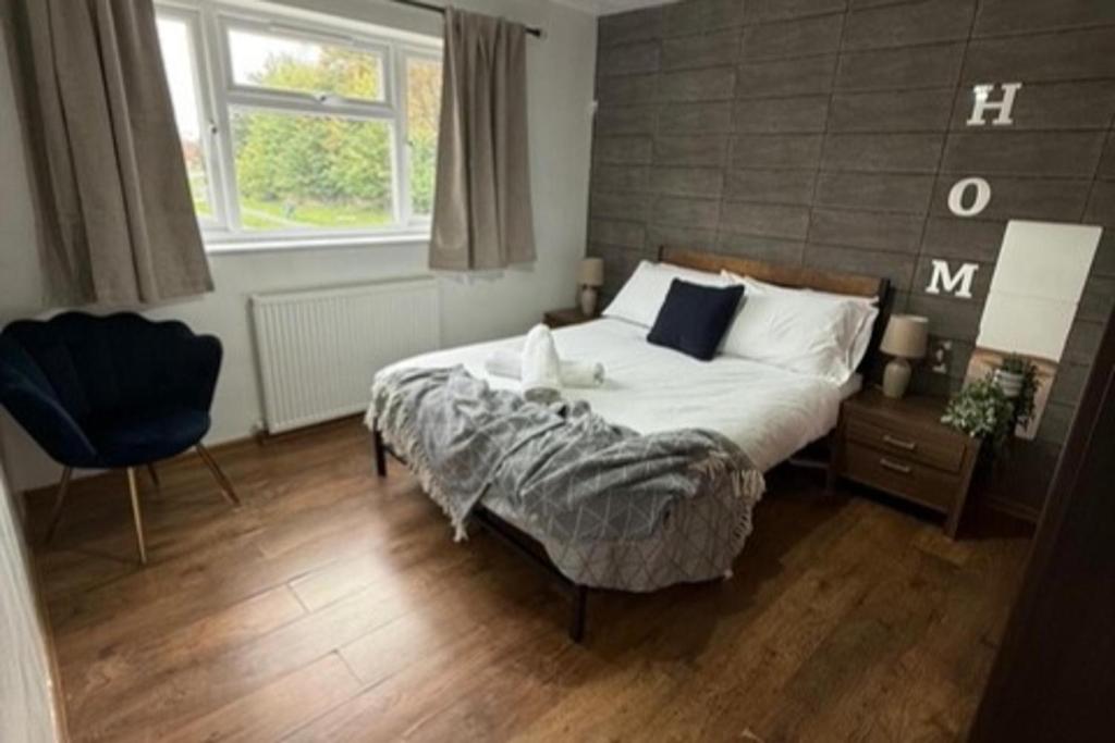 a bedroom with a large bed and a chair at Leamington Spa House with 4 Bedrooms in Leamington Spa