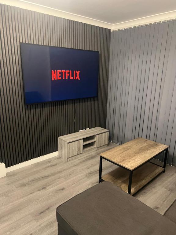 a television on a wall in a room at Jay3 Suites - Modern, Spacious & Charming One Bedroom Apartment in Dagenham in Dagenham