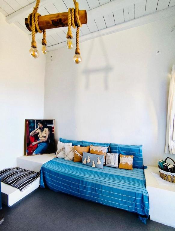 a room with a bed with a blue blanket at Vista Tinos in Triandáros