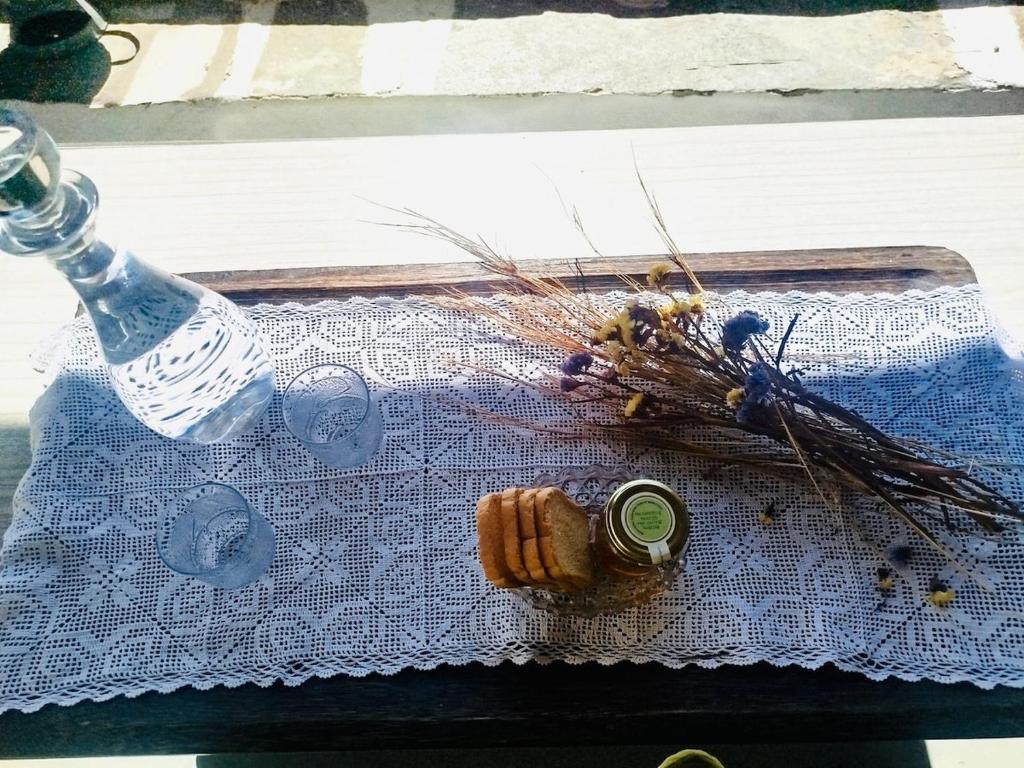 a bottle of water and a bunch of dried flowers on a table at Vista Tinos in Triandáros