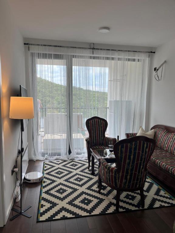 a living room with a couch and two chairs at Cozy apartment Kosmaj Residence in Rogača