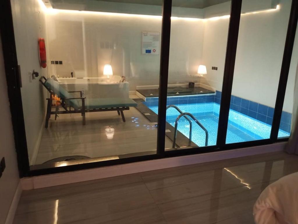 a view of a swimming pool through a window at شاليهات أجواء الريف in Dammam