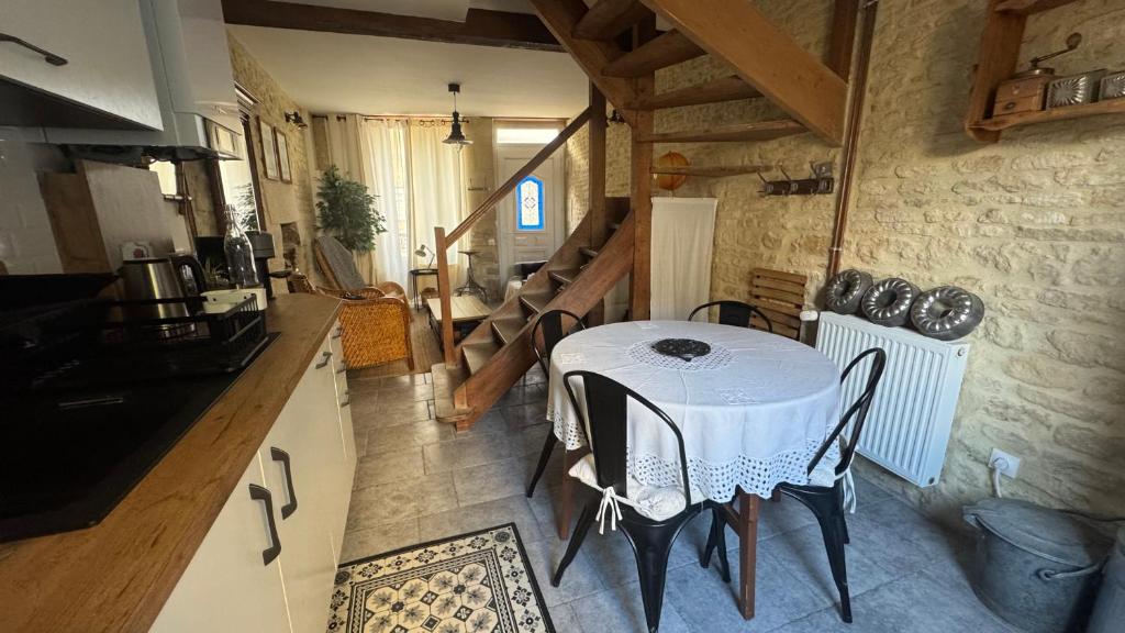 a kitchen with a table with a white table cloth at La Vigie - Maison en bord de mer in Lion-sur-Mer