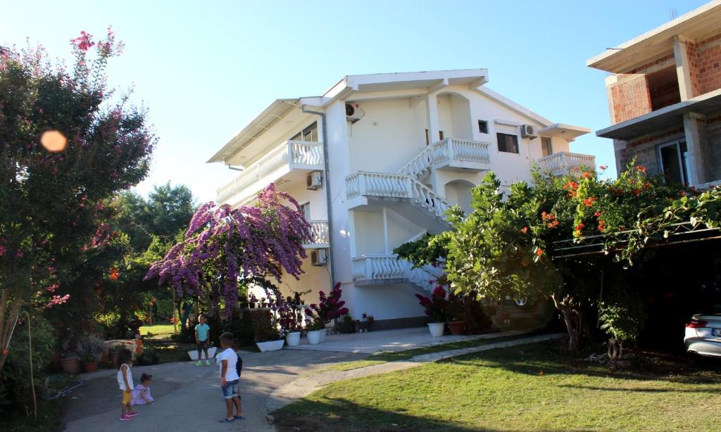 a building with two children walking in front of it at Apartaments A4 in Ulcinj