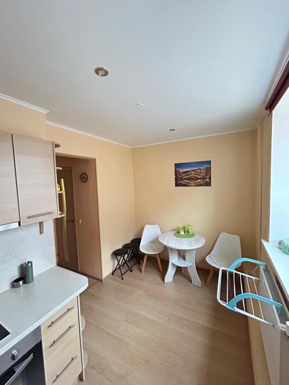 a kitchen and dining room with a table and chairs at Ligzdina in Auce