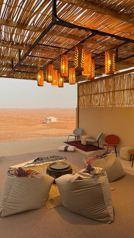 BadīyahFYAFY Bidiyah Bedouin Camp的沙漠中一间摆放着桌椅的房间