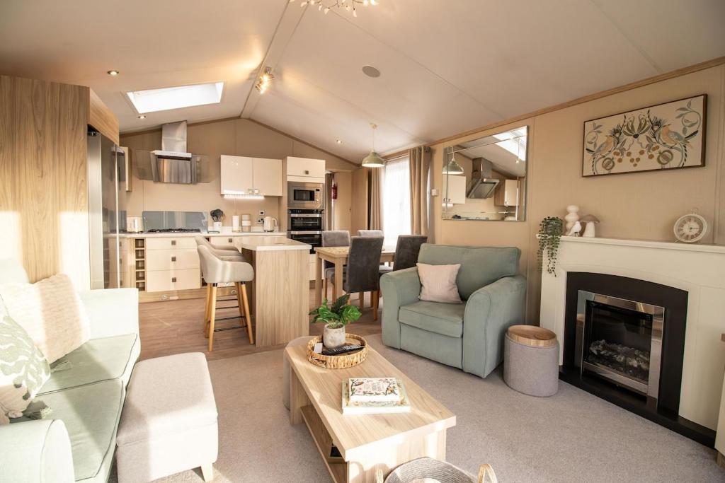 a living room with a couch and a fireplace at Starlings Nest at Hamilton Lodge in Kinmel Bay